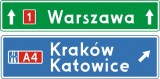 E-2f Drogowskaz tablicowy umieszczany nad jezdnią przed wjazdem na autostradę. Wskazuje na skrzyżowaniu lub bezpośrednio przed nim kierunki do miejscowości lub dzielnic miast